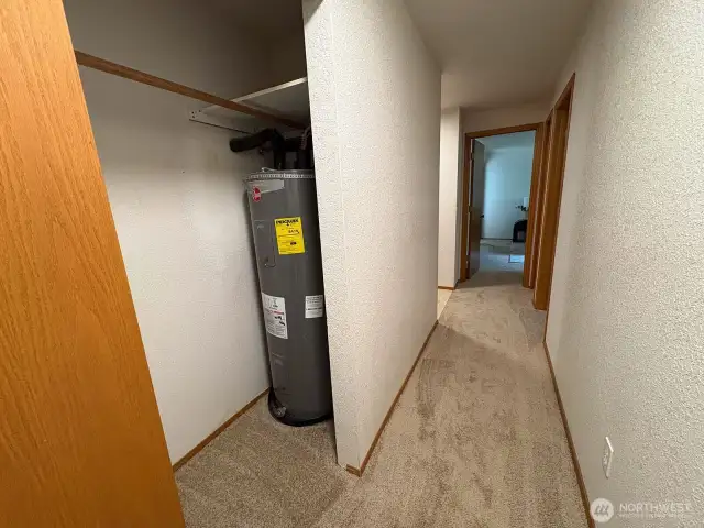 Hallway closet with easy access to the water heater.