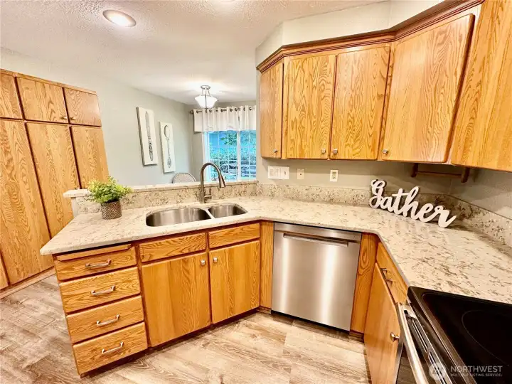 Kitchen with laminate flooring and quartz counter tops.