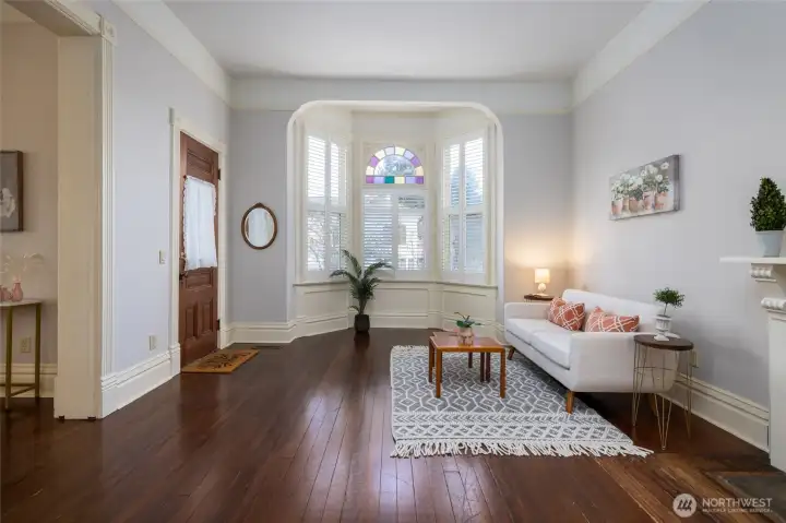 Elegant bay-window sitting room with classic fireplace.