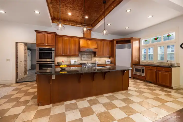 Spacious chef's kitchen with ornate tin ceiling.