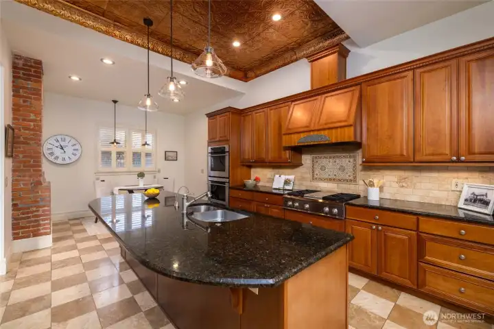 Spacious chef's kitchen with ornate tin ceiling.