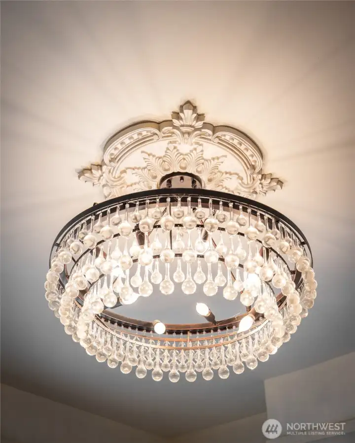 Elegant crystal chandelier with ornate ceiling medallion.