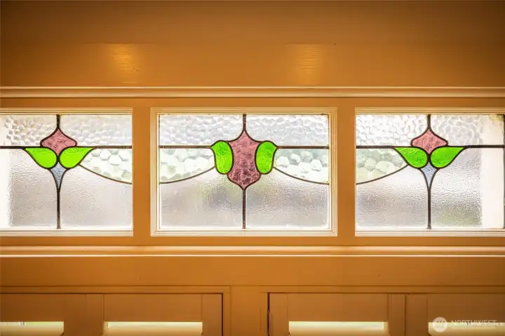 Colorful stained-glass transom windows with pink and green floral-style designs.
