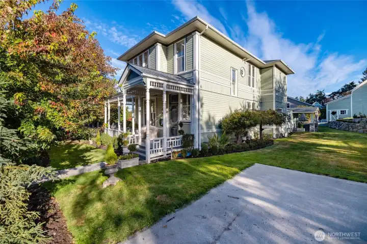 Sunny side yard with stone wall and patio chair.
