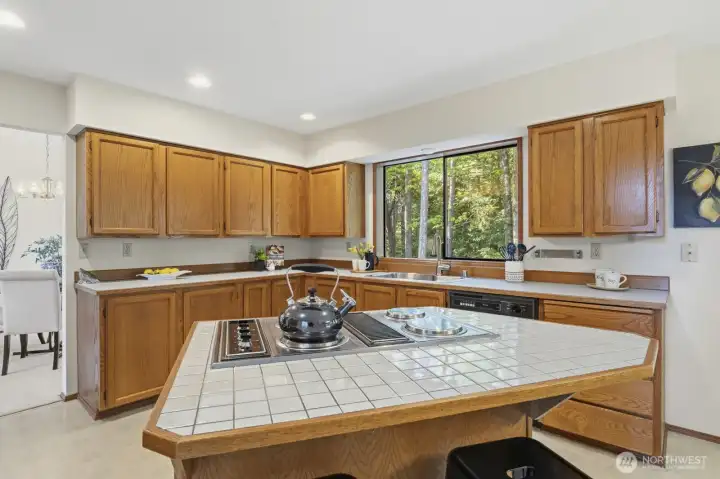 Off the formal dining room is the kitchen, offering ample counter space, abundant cabinetry, a pantry, and a central island.