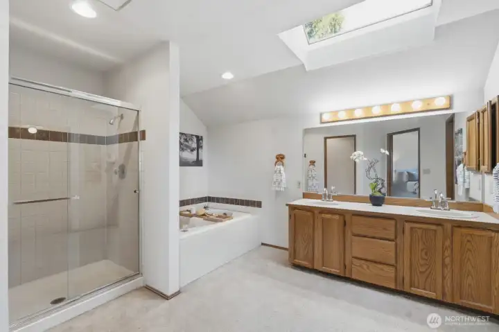An en suite featuring a soaking tub, dual-sink vanity, and a walk-in shower.