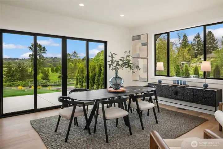 The expansive dining area features a large table perfect for gatherings, seamlessly leading out to a generous patio for outdoor entertaining