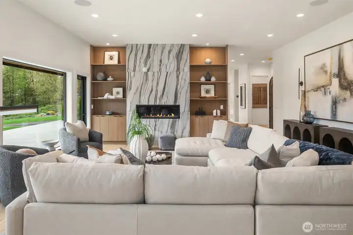The dramatic gas fireplace is elegantly flanked by bookshelves, creating a cozy yet sophisticated focal point.