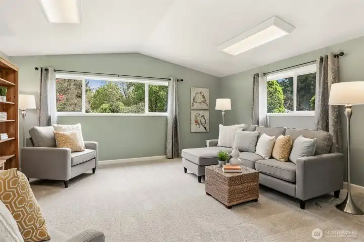 Beyond the laundry space is a large family room with vaulted ceilings.