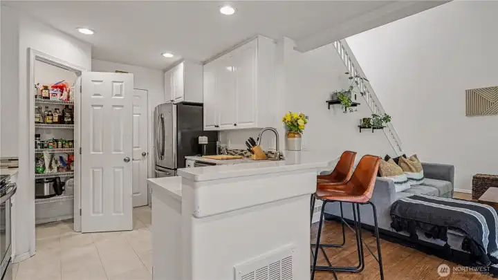 Light and bright kitchen with new vinyl plank flooring, stainless appliances and walk in pantry