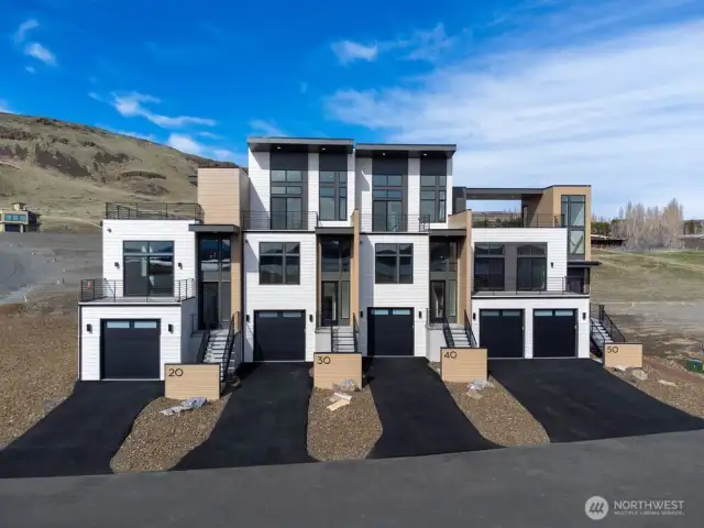 Gorgeous townhomes featuring expansive windows, ample parking, and multiple outdoor decks.