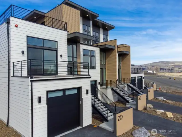Gorgeous townhomes featuring expansive windows, ample parking, and multiple outdoor decks.