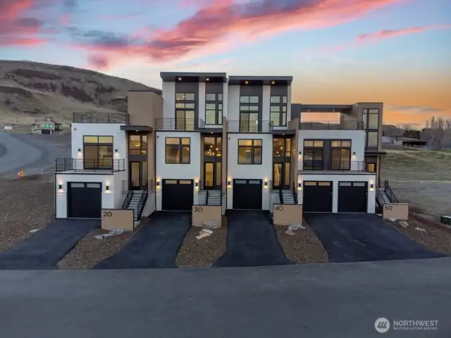 Gorgeous townhomes featuring expansive windows, ample parking, and multiple outdoor decks.