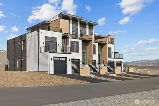 Gorgeous townhomes featuring expansive windows, ample parking, and multiple outdoor decks.