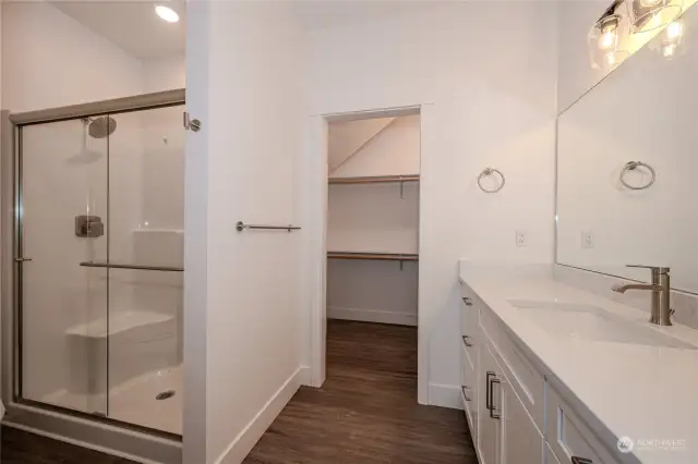 The Guest Bathroom boasts a sizable vanity with gorgeous quartz counters and a full tile shower with a sleek sliding glass door.