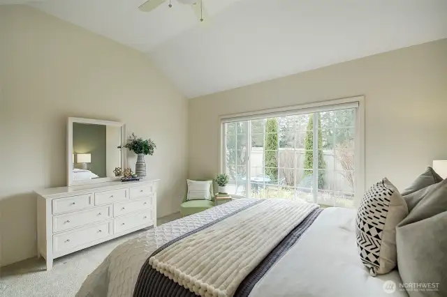 The Primary Bedroom features windows that overlook the landscaped patio area.