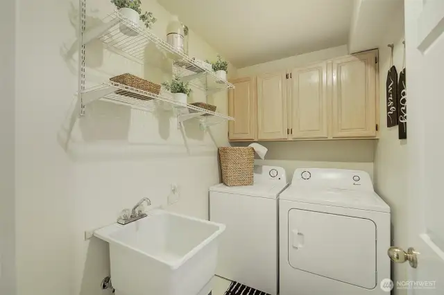The laundry room includes a deep soaking tub and overhead cabinets.  Appliances are also included with your purchase of this home.
