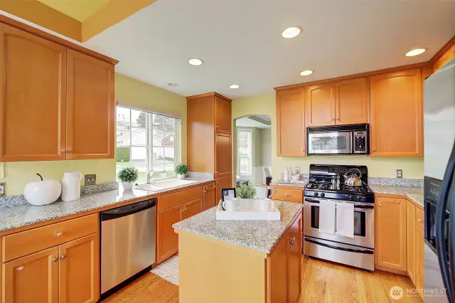 The heart of the home is the bright and airy kitchen, showcasing gleaming hardwood floors, stainless steel appliances, and gorgeous granite countertops.