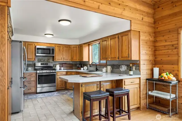 Bar stool seating and additional storage on the outside of the peninsula. Newer appliances in this good sized kitchen.