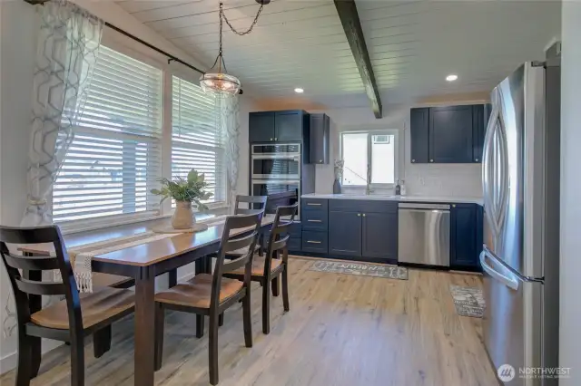 The kitchen features sleek stainless appliances, quartz countertops, and a stylish tile backsplash.