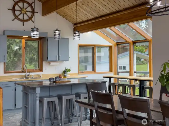Kitchen with island, glass breakfast nook with a water view & open to the large dining area.