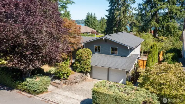 Custom home surrounded by lush mature landscaping.