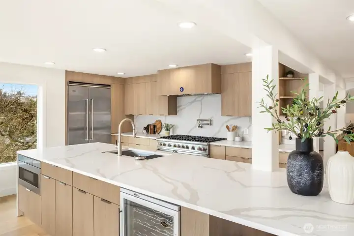 Designed for effortless entertaining with a sprawling 14’ counter, dedicated space for a wine or beverage fridge, and thoughtful conveniences including a bottle cleaner and disposal.