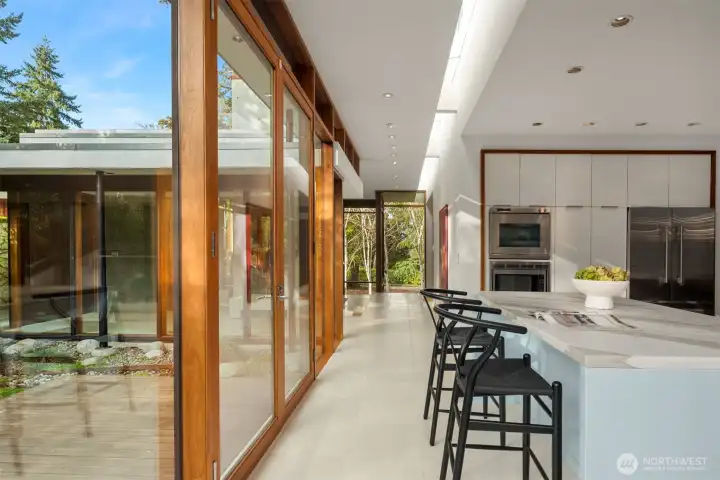 Walnut-wrapped walls of glass dissolving indoors and out. Throughout, the trimless detailing and built-ins keep the aesthetic clean and intentional—architecture first, always.