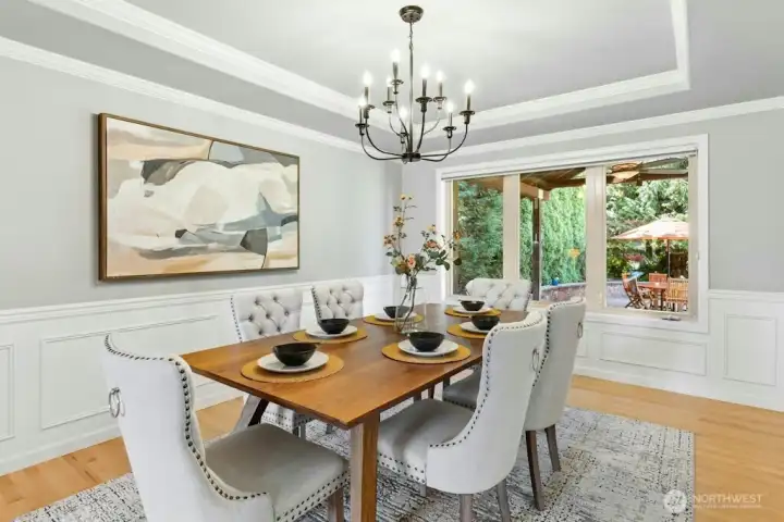Formal dining room with cove ceiling, crown molding, and updated lighting look onto the backyard and Covered patio area