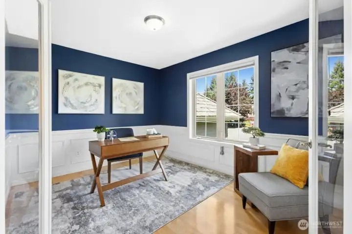 French doors into the sizable office/den with hardwood flooring, wainscoating, and plenty of light