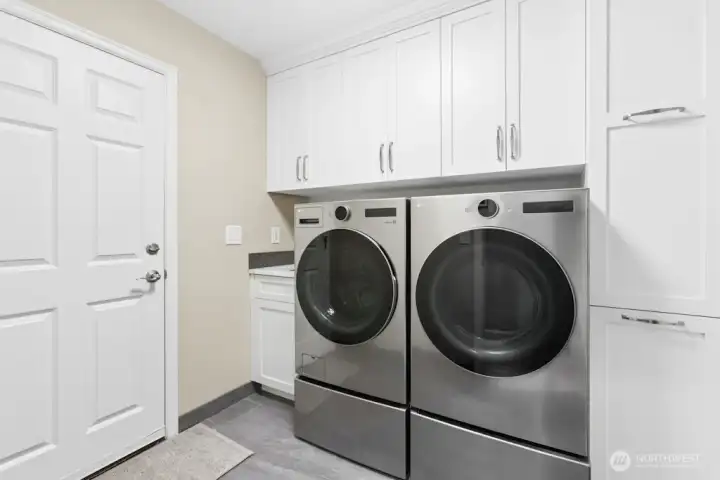 Fully remodeled laundry room with newer LG washer and dryer and access to the garage