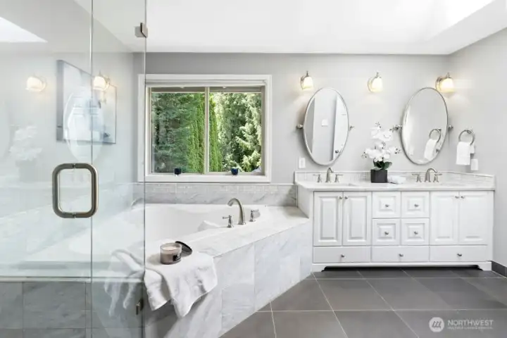 Enjoy the fully remodeled spa like primary bathroom with marble countertops, basalt stone flooring, and frameless shower!