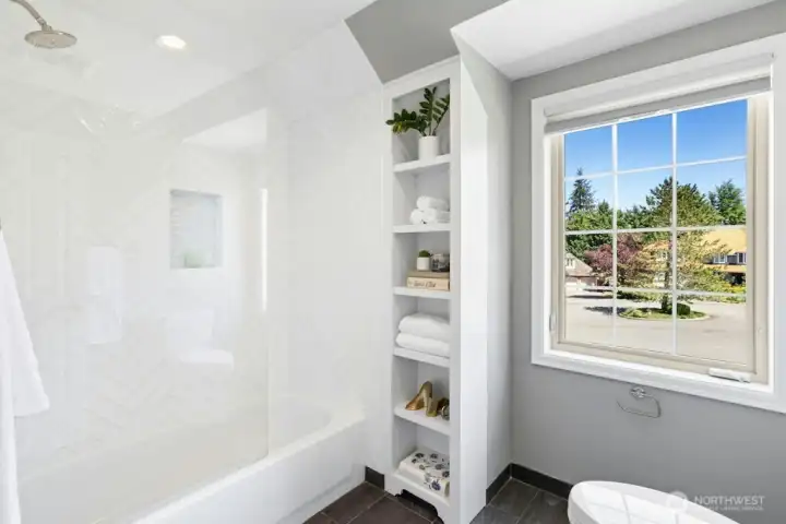 The frameless tub surround also opens on a hinge for convenience! The built-ins provide plenty of space for extra towels and decor!