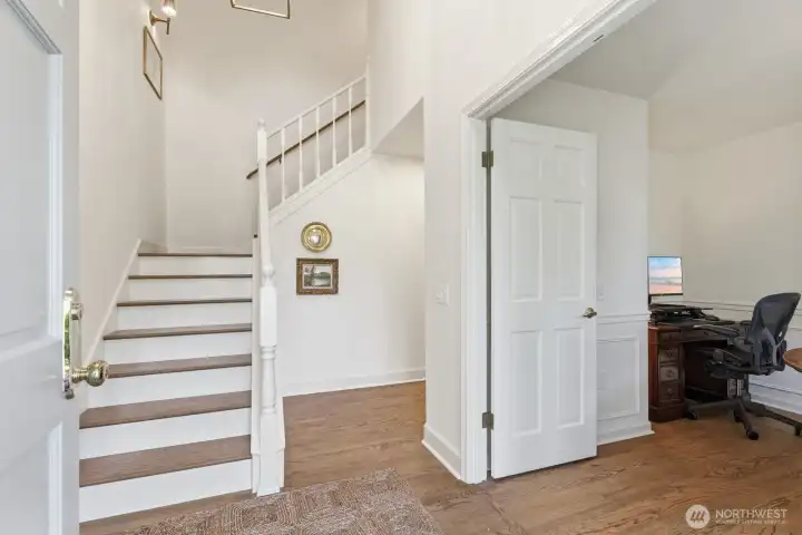A soaring entry where a striking hardwood staircase sets the tone for the home’s elevated presence.