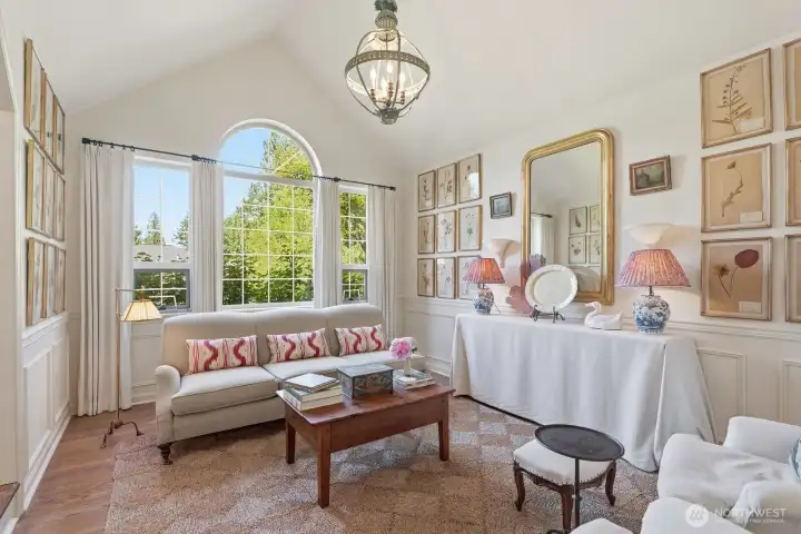 Enchanting living room with vaulted ceiling and wainscoting.