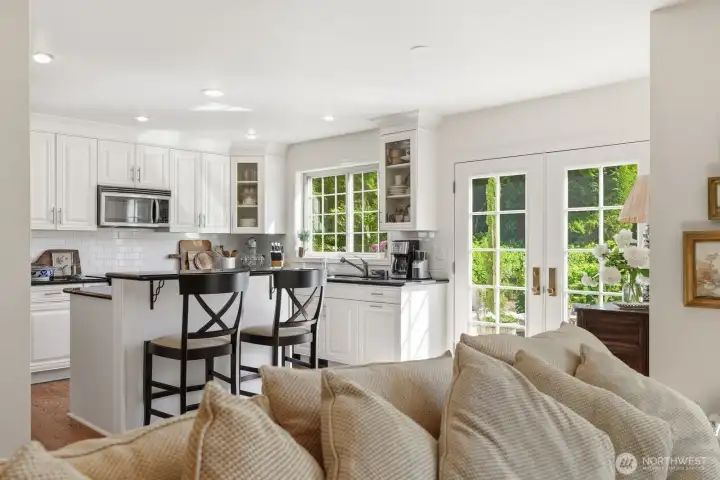 French doors lead to the beautifully landscaped backyard with a 600 sq/ft entertainment size stone patio.