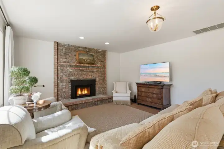Informal gathering area featuring a brick surround gas fireplace.