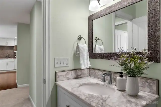 Steps from the kitchen, this full bathroom also serves as a powder room.