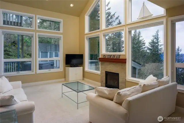 Greeted with light filled living room surrounded by windows. Trees, water, mountains!