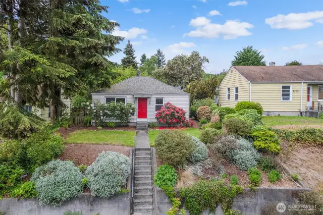 This home sits high off the street and enjoys great curb appeal with rhododendrons in the front, back and side yards. There's a territorial view, too, from the 6,400 square feet lot.