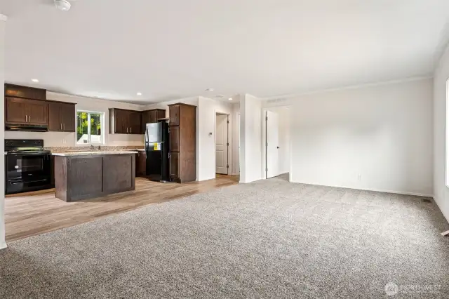 Wonderful open living room with oatmeal colored carpet underfoot creating a comfy environment.