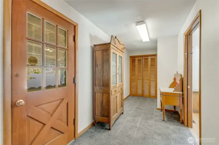 Entrance from carport area leading to primary suite, laundry room and additional closet