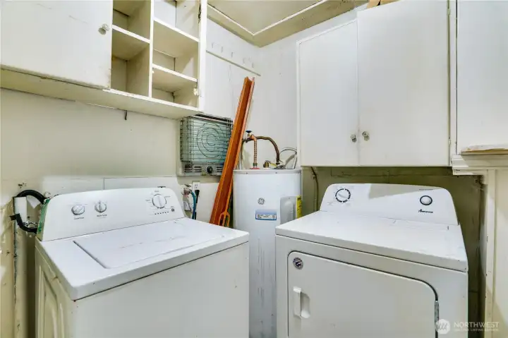 Utility room includes washer, dryer, and storage cabinets—functional space to build on.
