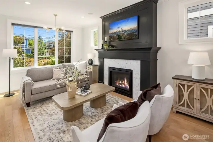 Living room has a gas fireplace large south facing windows with automated roller shades.