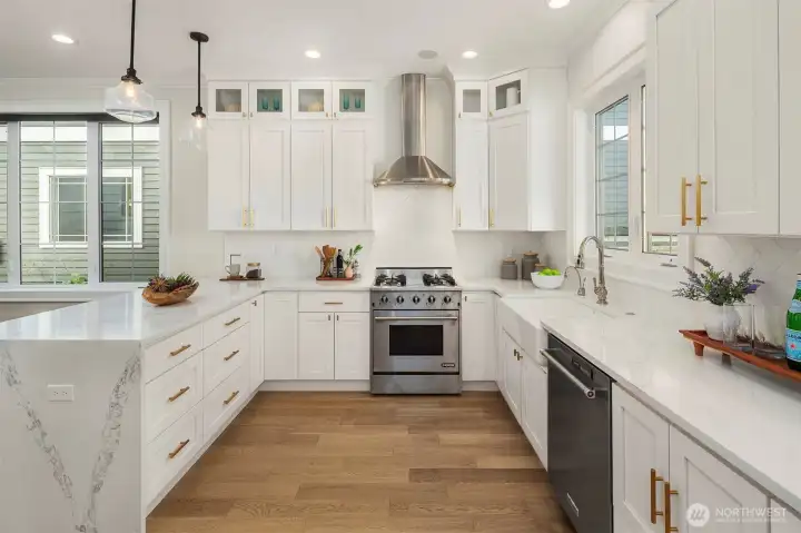 Quartz counters with waterfall edge and stainless steel appliances.