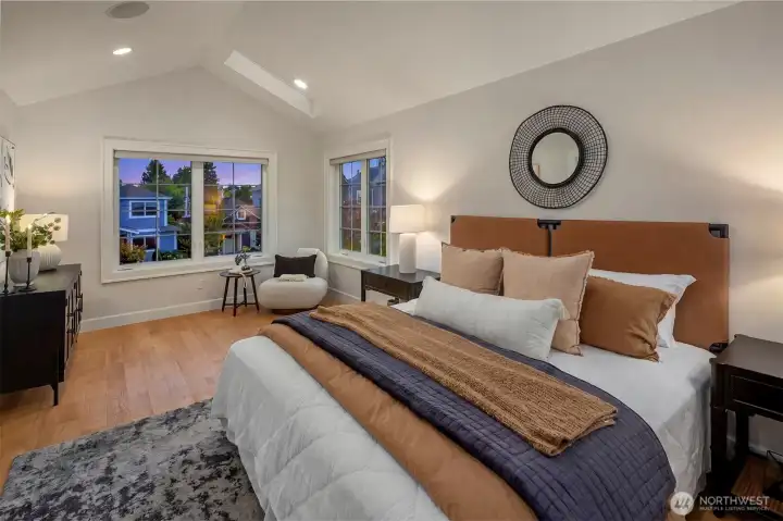 Large primary bedroom with vaulted ceilings and built in speakers.