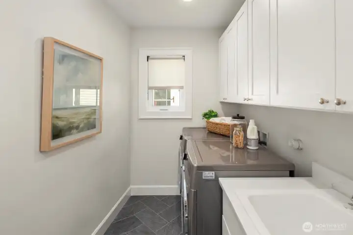 Walk in laundry room with utility sink and storage.