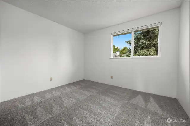 Sizable guest bedroom with a large window.