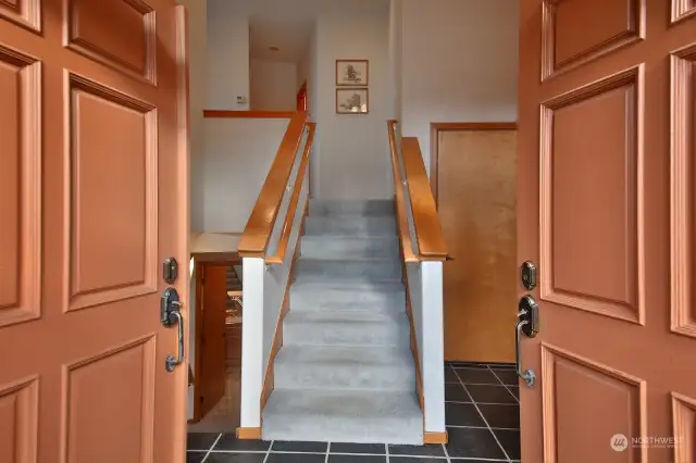 Slate floors greet you. Stairs up lead to the main level. Door to the right of the stairs leads to your 2 car garage. Hallway to 1/2 bath at top of stairs. Glimpse of lower level bath at base of stairs (left edge of photo).