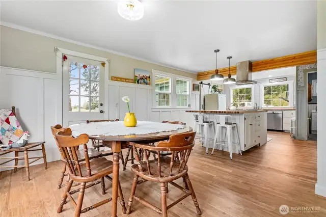 The dining area has lots of room to gather and the door pictured leads to a side patio, perfect for outdoor meals and convenient grilling.